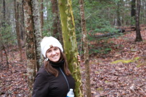 A picture of Jena posing by some trees in Conestee Nature Reserve in South Carolina.